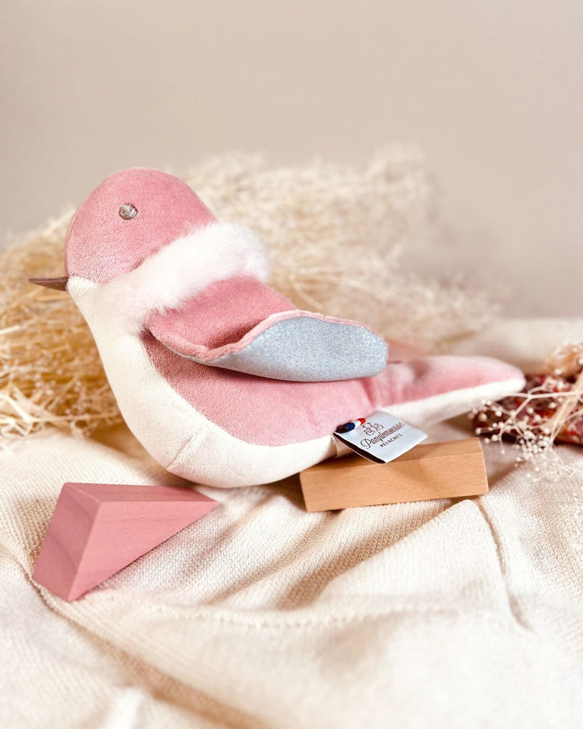 Pink plush toy with a tag on a soft beige background