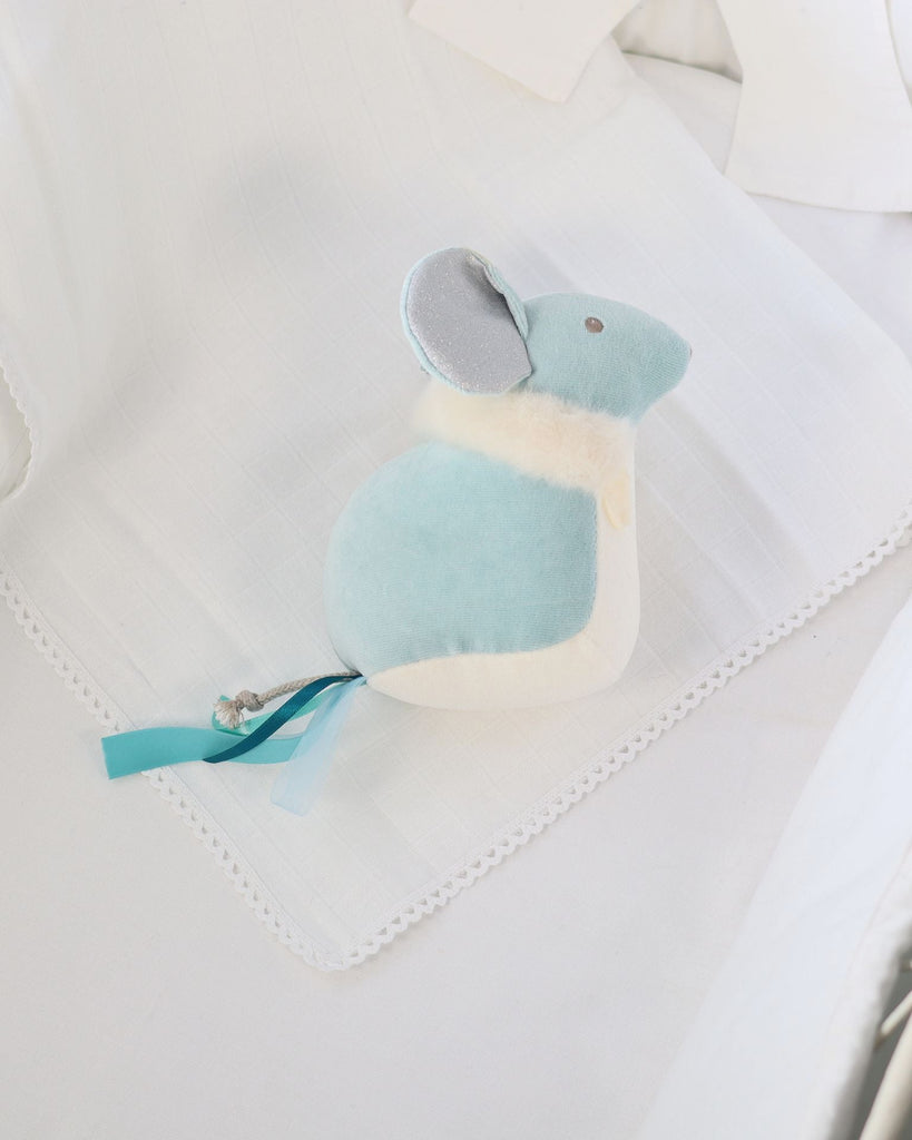 Small blue and white plush toy on a light fabric background