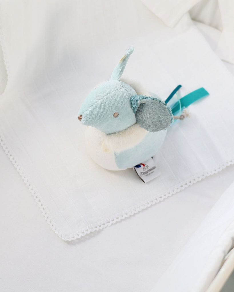 Plush toy with a tag on a white blanket