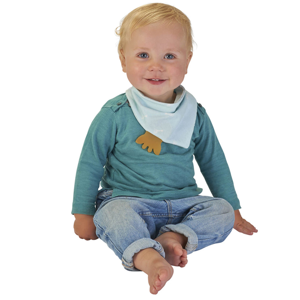 A smiling baby wearing a blue sophie the giraffe bandana