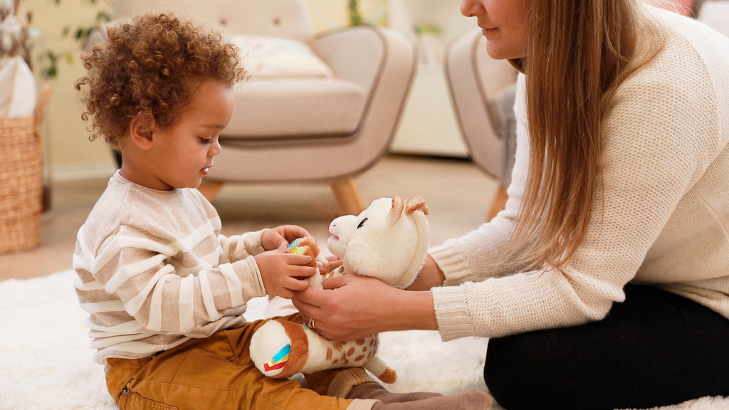 Mother and son playing with sophie musical plush