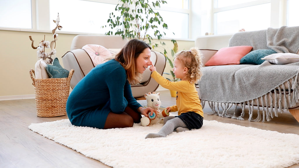 Mother and daughter playing with sophie musical plush