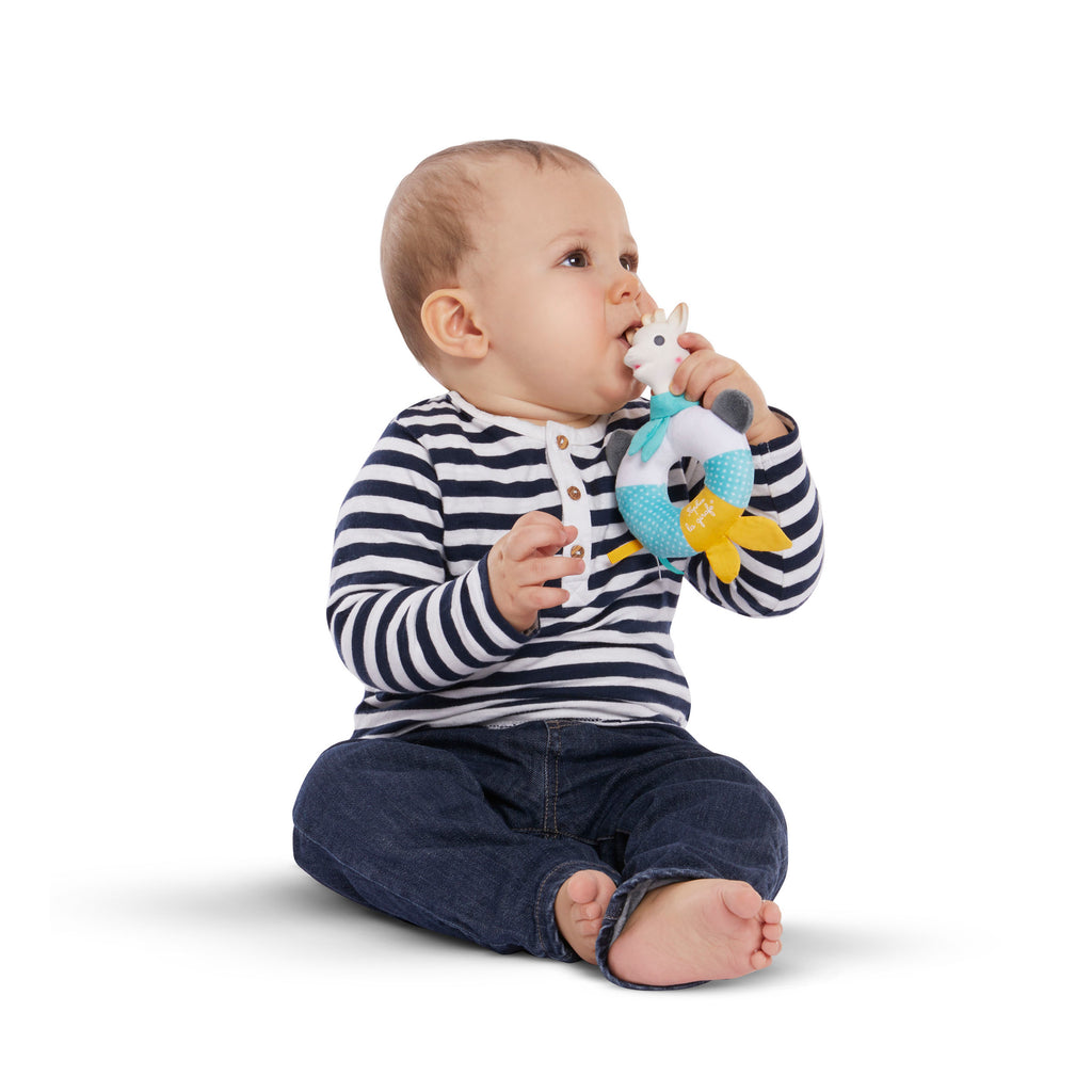 Baby teething on sophie shake and chew rattle