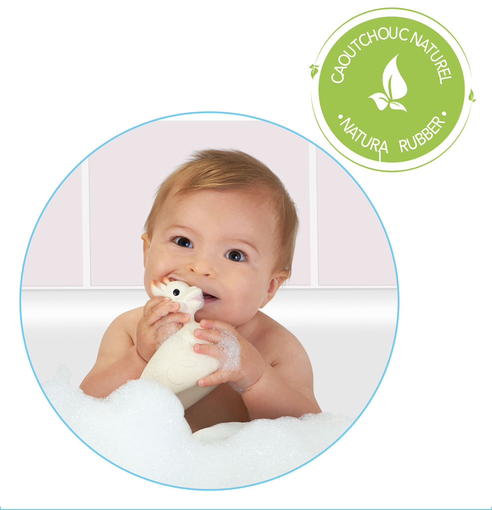 smiling baby teething on natural rubber sophie so'pure bath toy in the bathtub