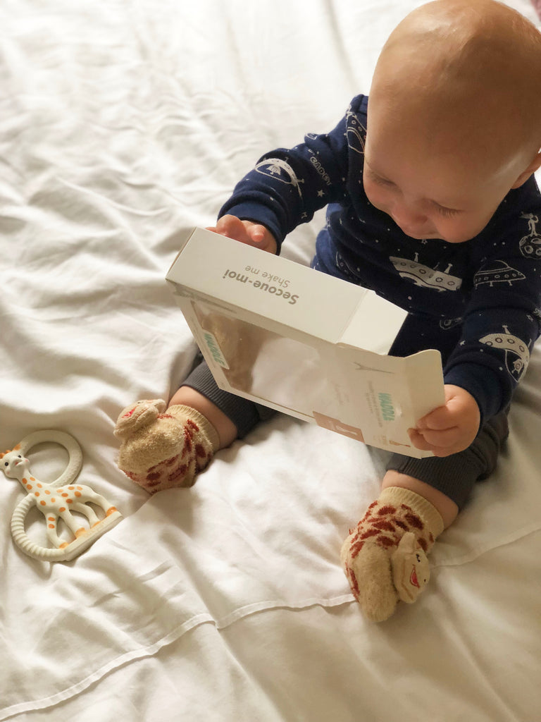 Baby wearing sophie waddle rattle socks and unboxing teething ring